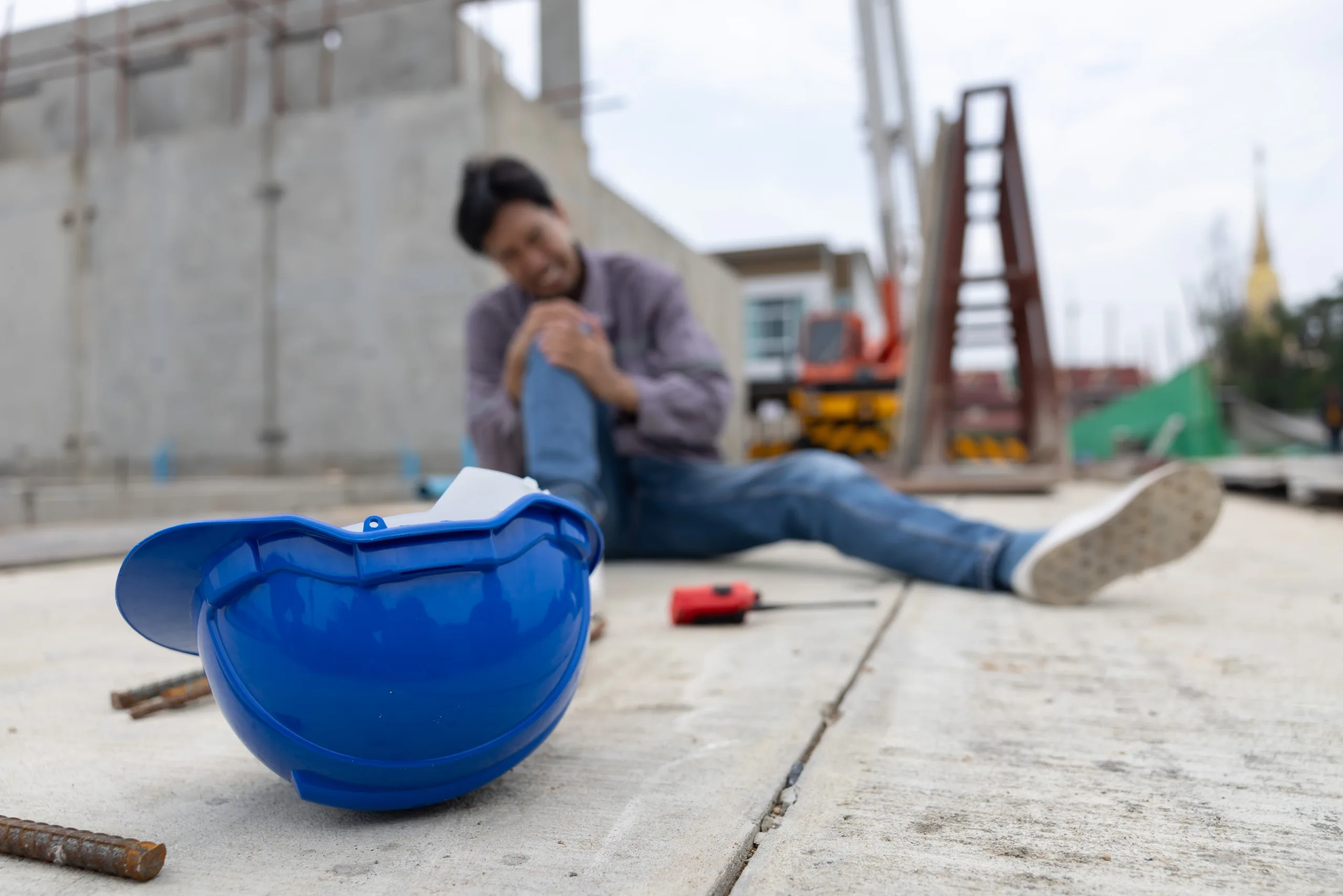 construction worker holding his knee on a work site